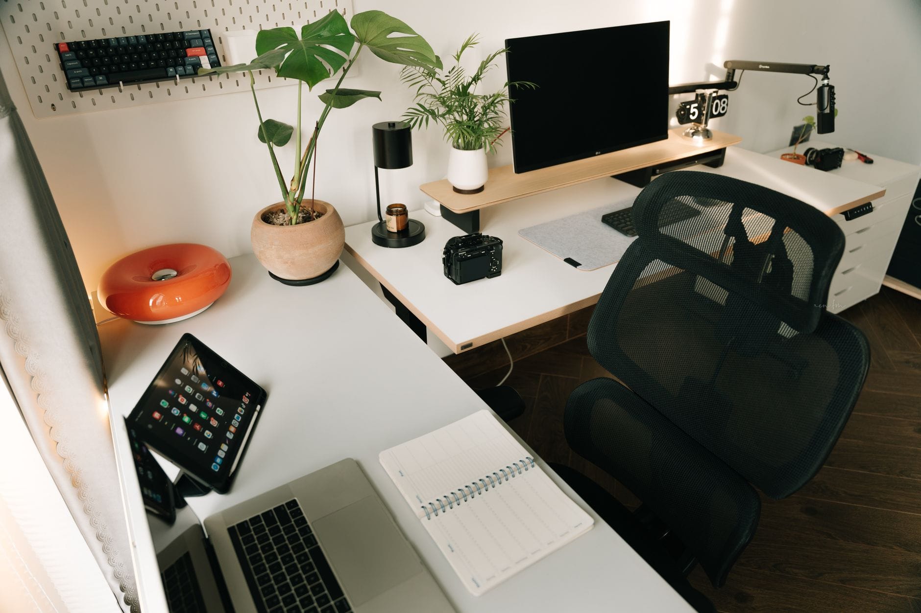 Minimalistyczne domowe biuro z monitorem tabletem i roślinami