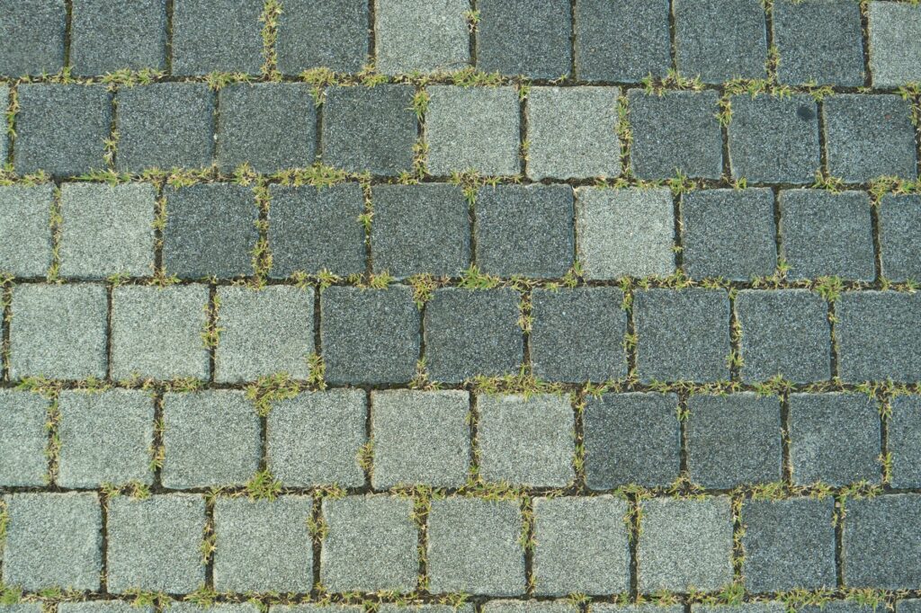 Czyszczenie kostki brukowej z mchu i plam oleju – domowe sposoby a myjka ciśnieniowa